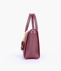 Buy Burgundy handbag with flower charm in Pakistan